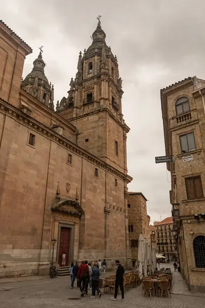 SALAMANCA, İspanya - 3 Temmuz 2024: Clereca Kilisesi 'nin Barok kuleleri, İspanya' nın Salamanca kentindeki ikonik Casa de las Conchas 'ın yanında yükseliyor.