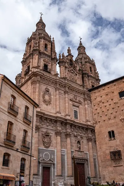 SALAMANCA, İspanya - 3 Temmuz 2024: Clereca Kilisesi 'nin Barok kuleleri, İspanya' nın Salamanca kentindeki ikonik Casa de las Conchas 'ın yanında yükseliyor.