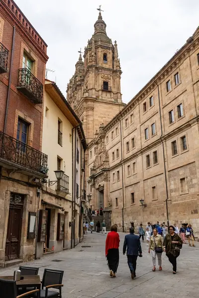SALAMANCA, SPAIN - 3 Temmuz 2024: Salamanca İspanya 'da eski bir kasaba caddesi İglesia La Clereca Katolik Kilisesi' nin Salamanca 'daki kulelerinin manzarası ile kasabada yürüyen insanlar