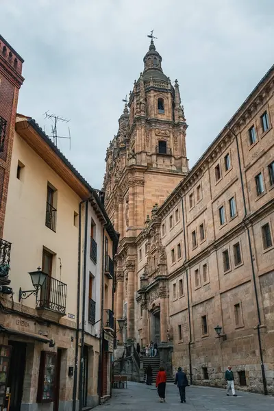 SALAMANCA, SPAIN - 3 Temmuz 2024: Salamanca İspanya 'da eski bir kasaba caddesi İglesia La Clereca Katolik Kilisesi' nin Salamanca 'daki kulelerinin manzarası ile kasabada yürüyen insanlar