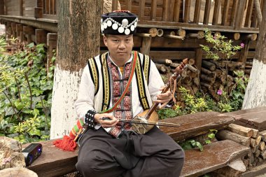 KUNMING, ÇİN - 20 Mart 2025: Yunnan 'ın Yi halkı için geleneksel bir enstrüman olan Horsehead Fiddle olarak da bilinen Touwenxian müzik aleti çalan Çinli adam