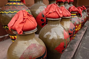 Çin 'in Kunming kentindeki Yunnan Etnik Köyünde geleneksel Çin şarap kavanozları ve kırmızı bez kapaklı ve el yazısı etiketleri sergilenmektedir.