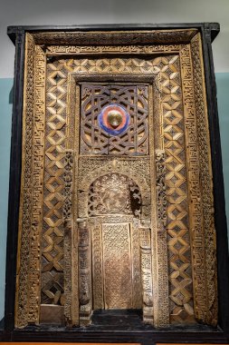 DUSHANBE, TAJIKISTAN - August 20, 2025: Intricately carved wooden mihrab with geometric and floral patterns, displayed in the National Museum of Tajikistan in Dushanbe