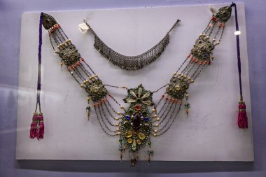 DUSHANBE, TAJIKISTAN - August 20, 2025:  Traditional Tajik jewelry collection displayed in the National Museum of Tajikistan in Dushanbe, featuring ornate necklaces with silver, enamel, beads, and coin 