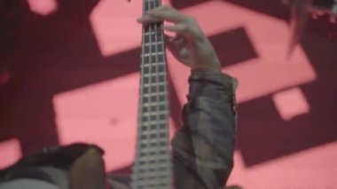 Bir müzisyen konserde gitar çalar.