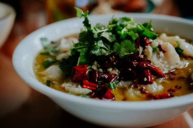 Geleneksel Tayland çorbası, beyaz balıklı, kırmızı biberli ve kişniş soslu.