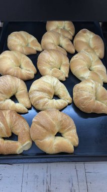 fırın tepsisindeki taze pişmiş kruvasanlar.