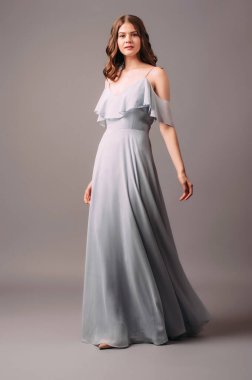 Mavi elbiseli güzel genç bayan. Stüdyoda yüksek topuklu ayakkabılarla dans eden esmer kadının stüdyo portresi. Bekarlığa veda partisi için nedime kıyafeti. Modern moda yaz kadınsı görünümü