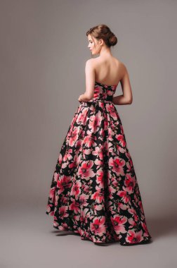 Cepleri ve pembe çiçek desenli sırt dekolteli balo elbisesi. Stüdyodaki çekici genç bayan, dikiz aynası. Kadın vesilesi bakışı. Bandeau korse etek maksi siyah elbise. Etkinlik için kolsuz şık kıyafet