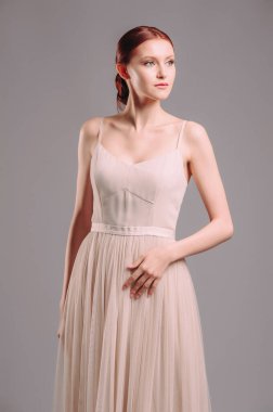 Fildişi bir yaz elbisesi içinde sevimli genç bir kadın. Kızıl saçlı, kolsuz ve kayışlı kadının stüdyo portresi. Nedime bekarlığa veda partisi arıyor. Şifon etekli korse akşam kıyafeti.