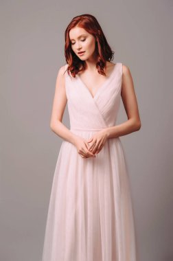 Baştan çıkarıcı kızıl saçlı, çapraz tüllü, pembe gelinlikli kadın. Çekici genç kızıl saçlı gelin, dokunaklı bir portre. Saf etekli güzel bir yaka elbisesi. Zarif gelinlik kadınsı görünümü