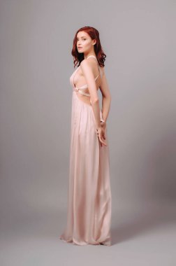 Pembe renkli transformatörsüz elbise. Maksimum gece elbisesi ve kurdeleli baştan çıkarıcı kızıl kadın. Nedimenin yaz ipek elbisesi. Kıvırcık saçlı, güzel, seksi bir bayan.