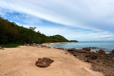 Uzak dağlar ve adalarla kayalık sahil ve denizin manzarası, mavi gökyüzü..