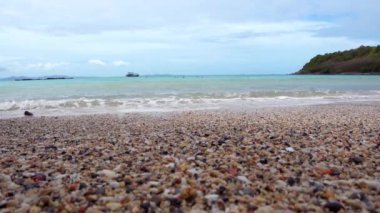 Uzak dağlar ve adalarla kayalık sahil ve denizin manzarası, mavi gökyüzü..