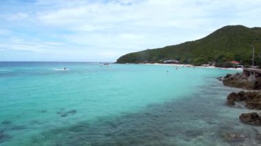 Uzak dağlar ve adalarla kayalık sahil ve denizin manzarası, mavi gökyüzü..