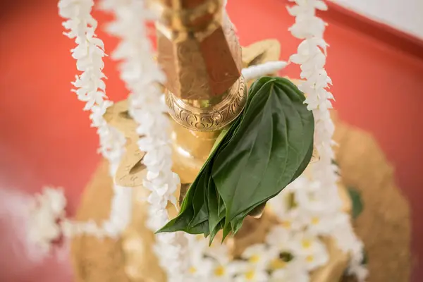 Betel leaves on an oil lamp with flower decorations