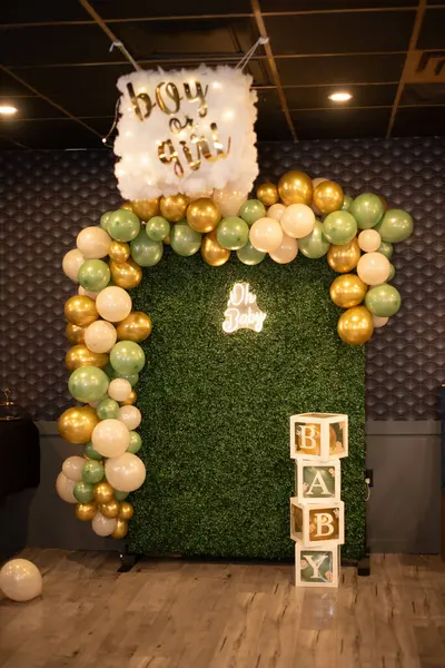 Süslü bir cinsiyetin dikey çekimi balonlarla ve dekorasyonlarla arka planı gözler önüne seriyor.