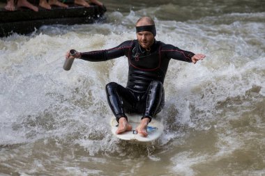 Münih, Almanya - Haziran 04, 2022: Şehir Nehrinde Sörfçü, Münih 'te Eisbach adı verilen kentsel çevrede sörf yapan insanlarla ünlüdür.