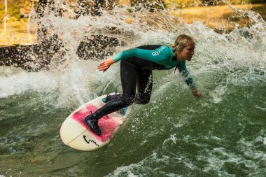 Münih, Almanya - Haziran 04, 2022: Şehir Nehrinde Sörfçü, Münih 'te Eisbach adı verilen kentsel çevrede sörf yapan insanlarla ünlüdür.