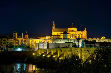 Cordoba, İspanya - 31 Ekim 2022: Mezquita-Katedral ve Puente Romano - Cami-Katedral ve gece İspanya 'nın Endülüs kentindeki Roma Köprüsü