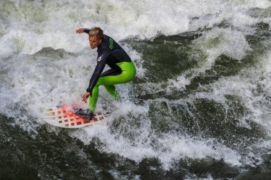 Münih, Almanya - Haziran 04, 2022: Şehir Nehrinde Sörfçü, Münih 'te Eisbach adı verilen kentsel çevrede sörf yapan insanlarla ünlüdür.