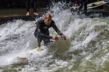 Münih, Almanya - Haziran 04, 2022: Şehir Nehrinde Sörfçü, Münih 'te Eisbach adı verilen kentsel çevrede sörf yapan insanlarla ünlüdür.