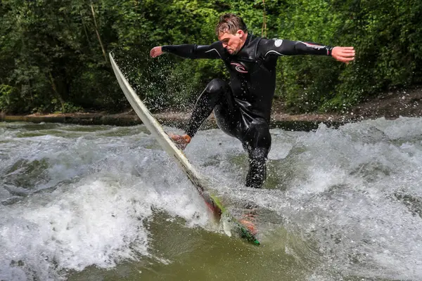 stock image Munich, Germany - Jun 04, 2022: Surfer in the city river, Munich is famous for people surfing in urban enviroment called Eisbach