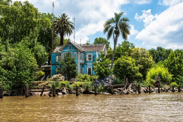Boat tour on the Parana Delta, Tigre, Buenos Aires, Argentina. Lush vegetation, palm trees, construction site of modern brick house. Lujan River delta system bringing water to Rio de la Plata.
