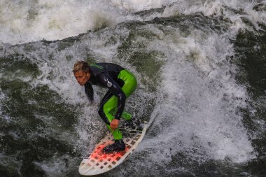 Münih, Almanya - Haziran 04, 2022: Şehir Nehrinde Sörfçü, Münih 'te Eisbach adı verilen kentsel çevrede sörf yapan insanlarla ünlüdür.