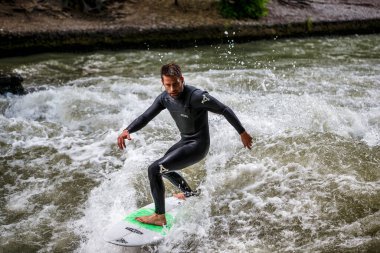 Münih, Almanya - Haziran 04, 2022: Şehir Nehrinde Sörfçü, Münih 'te Eisbach adı verilen kentsel çevrede sörf yapan insanlarla ünlüdür.