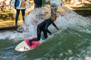 Münih, Almanya - Haziran 04, 2022: Şehir Nehrinde Sörfçü, Münih 'te Eisbach adı verilen kentsel çevrede sörf yapan insanlarla ünlüdür.