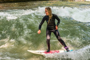 Münih, Almanya - Haziran 04, 2022: Şehir Nehrinde Sörfçü, Münih 'te Eisbach adı verilen kentsel çevrede sörf yapan insanlarla ünlüdür.
