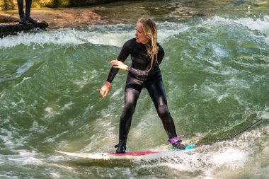 Münih, Almanya - Haziran 04, 2022: Şehir Nehrinde Sörfçü, Münih 'te Eisbach adı verilen kentsel çevrede sörf yapan insanlarla ünlüdür.