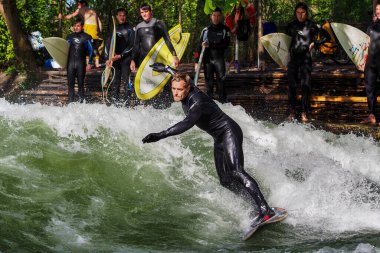 Münih, Almanya - Haziran 04, 2022: Şehir Nehrinde Sörfçü, Münih 'te Eisbach adı verilen kentsel çevrede sörf yapan insanlarla ünlüdür.