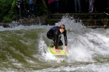 Münih, Almanya - Haziran 04, 2022: Şehir Nehrinde Sörfçü, Münih 'te Eisbach adı verilen kentsel çevrede sörf yapan insanlarla ünlüdür.