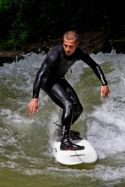 stock image Munich, Germany - Jun 04, 2022: Surfer in the city river, Munich is famous for people surfing in urban enviroment called Eisbach