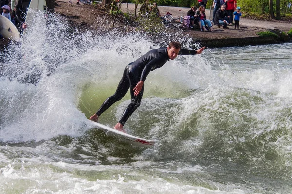 stock image Munich, Germany - Jun 04, 2022: Surfer in the city river, Munich is famous for people surfing in urban enviroment called Eisbach