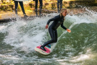 Münih, Almanya - Haziran 04, 2022: Şehir Nehrinde Sörfçü, Münih 'te Eisbach adı verilen kentsel çevrede sörf yapan insanlarla ünlüdür.