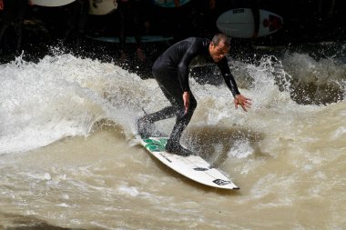 Münih, Almanya - Haziran 04, 2022: Şehir Nehrinde Sörfçü, Münih 'te Eisbach adı verilen kentsel çevrede sörf yapan insanlarla ünlüdür.