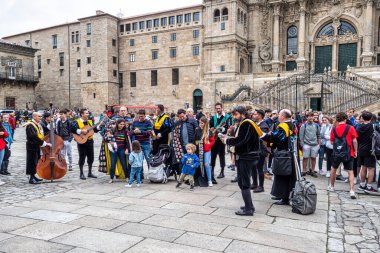Santiago de Compostela, İspanya - 19 Haziran 2023: Katedral önünde turist ve hacılarla birlikte Santiago de Compostela, Galiçya, İspanya 'da sahne alan sokak müzisyenleri.