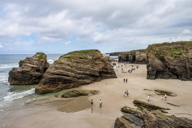 Ribadeo, İspanya - 22 Haziran 2023: İspanya 'nın Ribadeo kentindeki Playa de las kategorilerinde doğal kaya kemerleri. Kuzey İspanya Atlantik 'teki ünlü plaj.