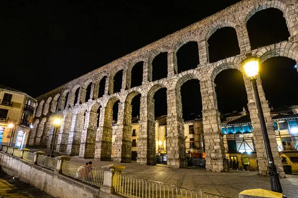 Segovia, İspanya - Temmuz 05, 2023: Gece vakti Segovia 'nın Roma Aqueduct' u, en iyi korunmuş Roma Su kemerlerinden biri ve Segovia 'nın bir sembolü. Kastilya ve Leon, İspanya.