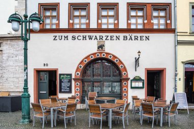 Weimar, Almanya - 11 Mayıs 2023: Lokantalar Almanya 'nın Weimar kentindeki Black Bear Restoranı' nda ve pazar meydanındaki bira evinde akşam yemeğinin keyfini çıkarıyorlar.