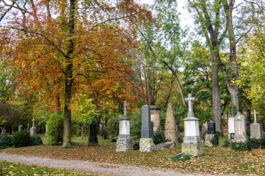Almanya 'nın Münih kentindeki ünlü Kuzey Mezarlığı' nın sonbahar manzarası. Tarihi mezar taşları var. Cenazeler 1944 'ten beri burada yapılmadı. Bunun yerine mezarlık bir park olarak kullanılıyor..