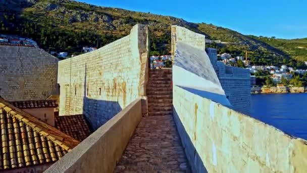 アドリア海のダルマチア沿岸のクロアチア ドゥブロヴニクの古代防衛都市の壁を歩く — ストック動画