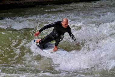 Münih, Almanya - Haziran 04, 2023: Şehir Nehrinde Sörfçü, Münih 'te Eisbach adı verilen kentsel çevrede sörf yapan insanlarla ünlüdür.