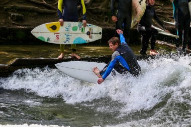 Münih, Almanya - Haziran 04, 2023: Şehir Nehrinde Sörfçü, Münih 'te Eisbach adı verilen kentsel çevrede sörf yapan insanlarla ünlüdür.