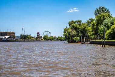 Tigre, Arjantin - 15 Aralık 2023: Parana Delta, Tigre, Buenos Aires, Arjantin tekne turu. Bereketli bitki örtüsü, palmiye ağaçları, modern tuğla evin şantiyesi.