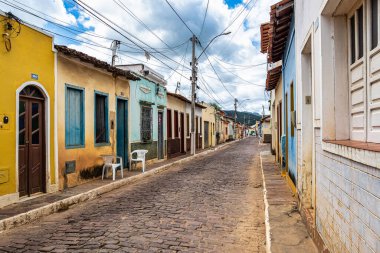 Palmeiras, Brazil - Jan 07, 2024: Street with colorful houses in colonial style and stone floor at Palmeiras in Vale do Capao in Chapada Diamantina, Bahia, northeast of Brazil clipart