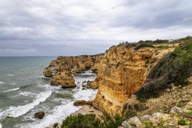 Praia da Marinha Sahili, Yedi Asılı Vadi Yolu 'ndaki kayalıkların ve kayalıkların arasında Percurso dos Sete Vales Suspensos. Algarve, Portekiz